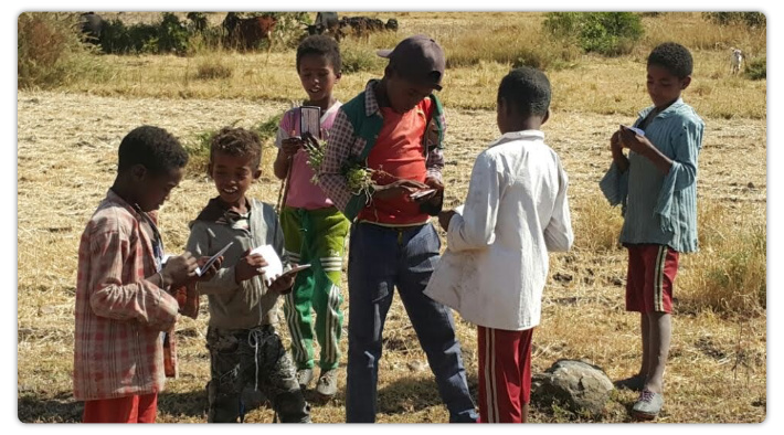 Kids reading Chick tracts in Ethiopia.