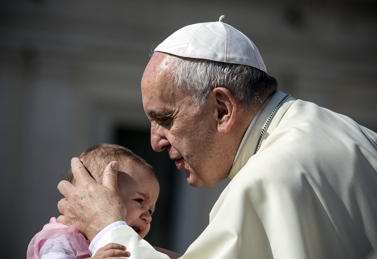 June, 2016: Pope Francis blesses crying child during a weekly ceremony in the Vatican City.